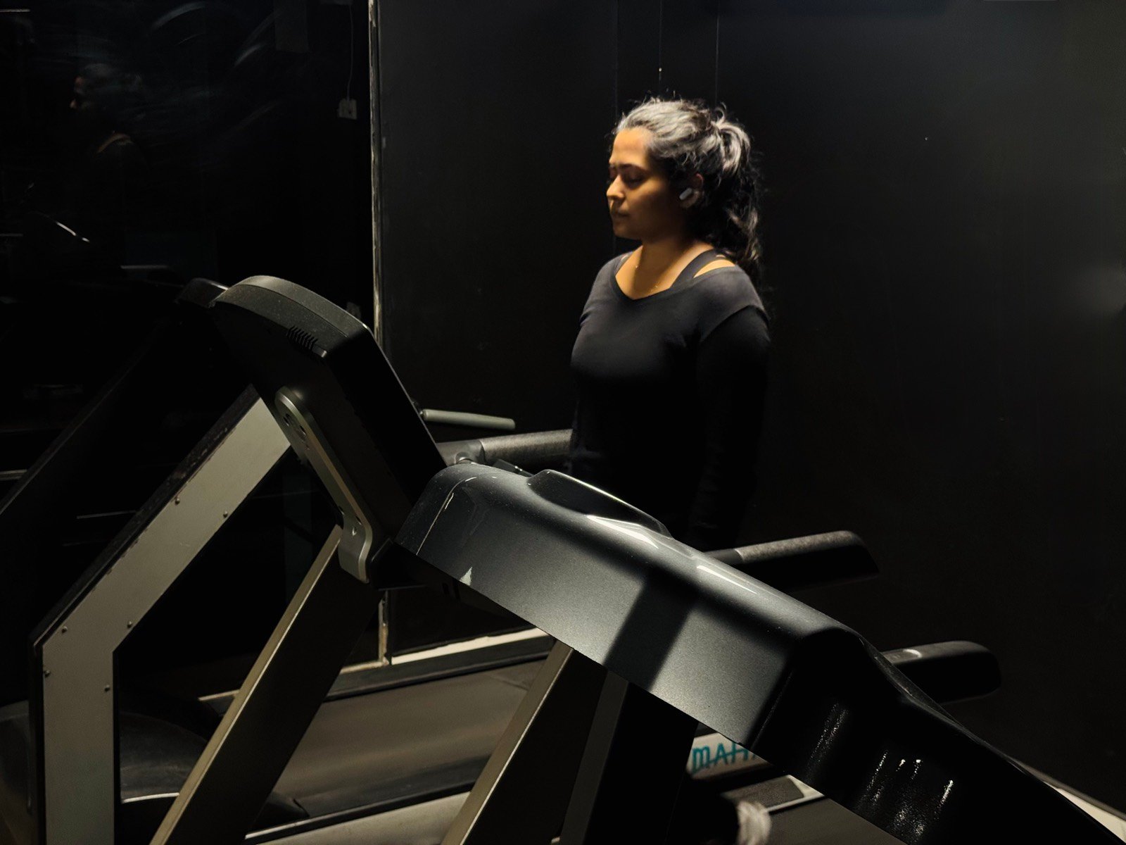 A member walking on a treadmill in the cardio area