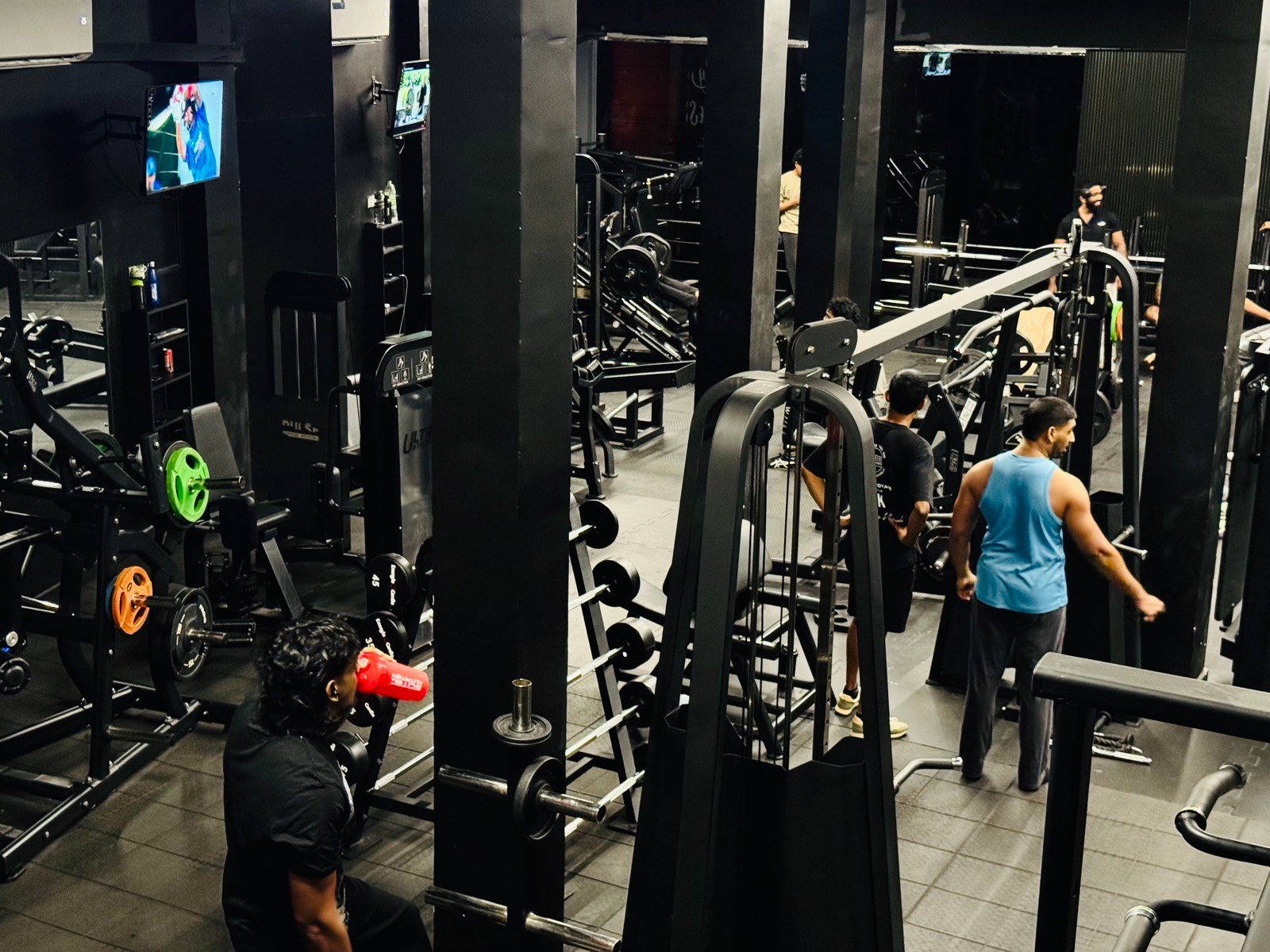 Cable machines and colour-coded plates along the training floor